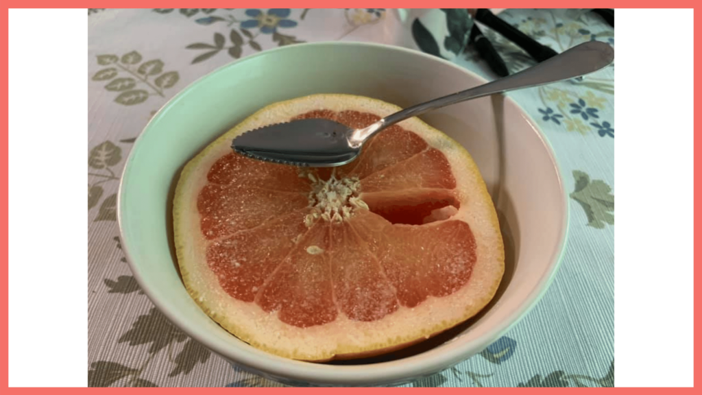 photo of a grapefruit with a grapefruit spoon, an example of little luxuries