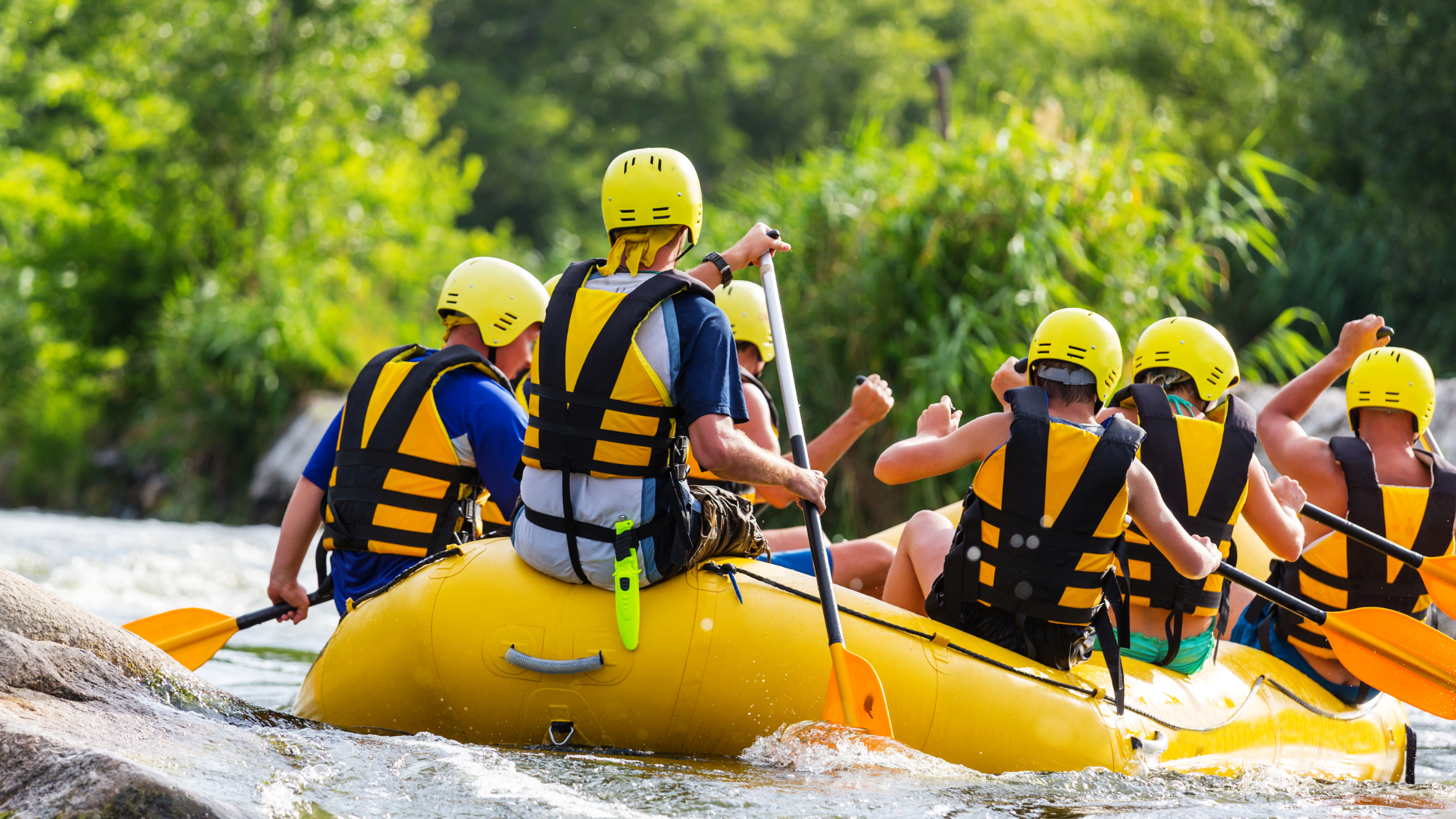 photo of a group of people white water rafting as a team